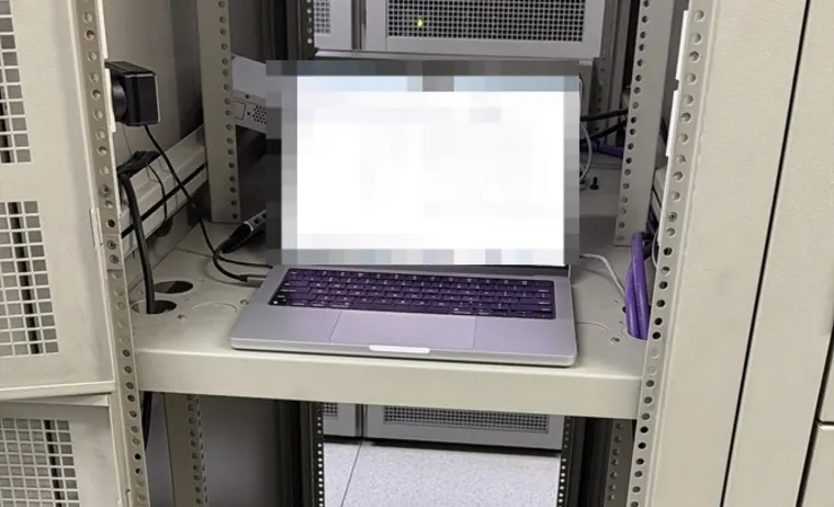 Notebook apoyada en la bandeja de un rack, conectada al equipamiento durante una intervención técnica